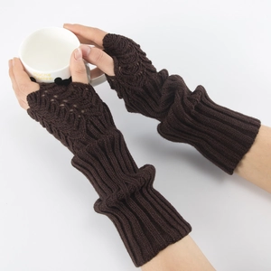 Detailed knit texture of dark brown fingerless arm warmers held over a warm coffee cup