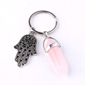 Pink hexagonal crystal and silver Hamsa hand charm pendant keychain on white background