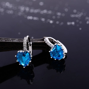 Fashionable silver hoop earrings with heart-shaped blue zircon and pavé white stones