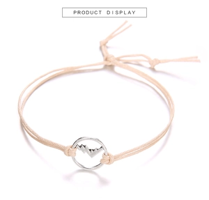Dettaglio del bracciale in corda intrecciata beige con ciondolo a cerchio montano argento