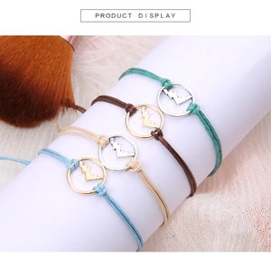Primo piano di quattro braccialetti bohémien intrecciati colorati con ciondoli a fulmine