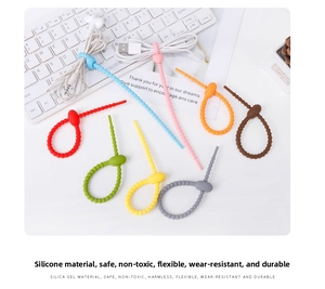 Colorful silicone cable ties bundling USB data lines and earphones on a white desk