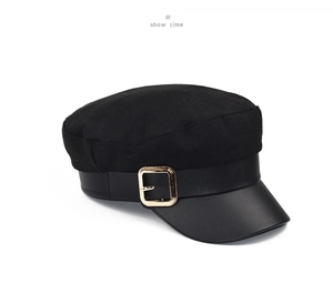 Detail of the textured wool crown and faux leather brim on this black newsboy cap