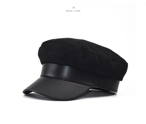Detailed view of black newsboy cap featuring wool fabric texture and PU leather brim