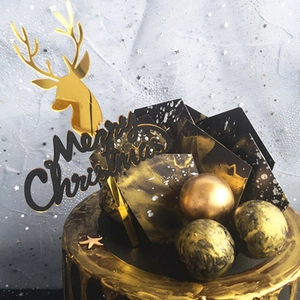 Detail of luxury gold reindeer silhouette and black Merry Christmas acrylic cake toppers