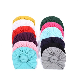 Mise à plat de bonnets turban bébé en douze couleurs dont le rose et le bleu marine