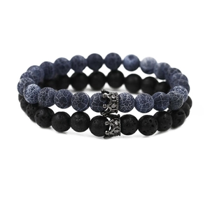 Detail of beaded bracelet set with blue vein stone, black lava rock and zircon crown charms