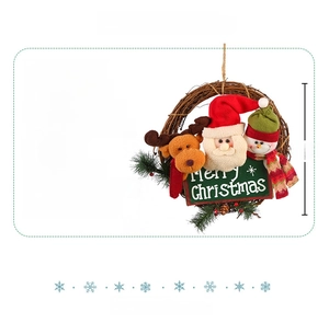 Détail de couronne de Noël en rotin avec figurines en peluche et panneau Merry Christmas