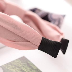 Close-up of pink twisted fabric headband with soft texture and black end tips