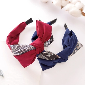 Detail of fabric bow headbands with paisley patchwork in dark red and navy blue