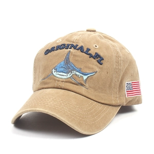 Detail of shark embroidery and American flag patch on washed khaki baseball cap