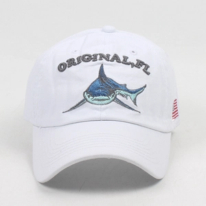 Close-up of blue shark embroidery and American flag patch on a white baseball cap