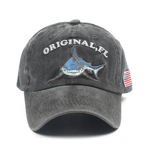 Detail of shark embroidery and flag patch on washed gray cotton baseball cap