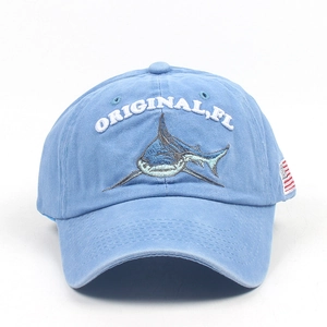 Detail of embroidered shark and letters on a vintage washed blue cotton baseball cap