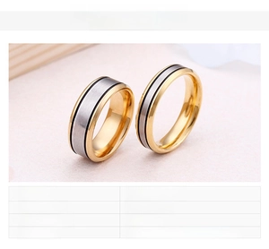 Detail of 18K gold plated titanium couple rings with silver brushed texture and black lines