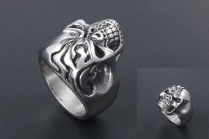 Macro side view of silver skull ring with detailed flame textures on band