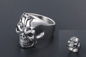Macro view of silver skull ring with detailed metallic texture and polished finish
