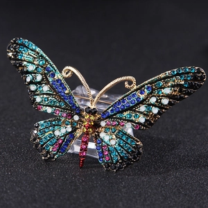 Detailed macro view of vibrant colorful rhinestones on a gold butterfly brooch