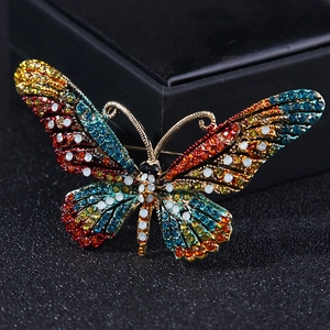 Close-up of a luxury butterfly brooch with colorful rhinestones on a black background