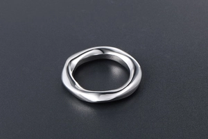 Détail macro d'une bague torsadée argentée avec finition polie sur fond gris foncé