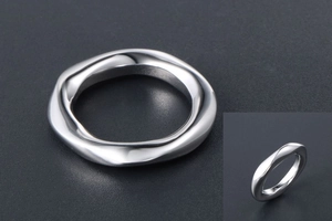 Détail macro de la bague torsadée argentée avec un design minimaliste de vague fluide