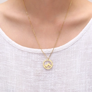 Collana minimalista con pendente a montagna circolare placcata oro 18K indossata da modella