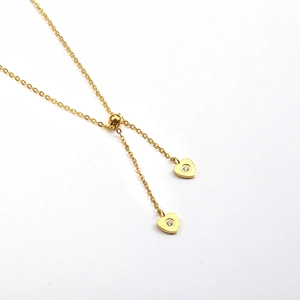 Detail of adjustable gold necklace featuring two micro-pave heart pendants with crystals