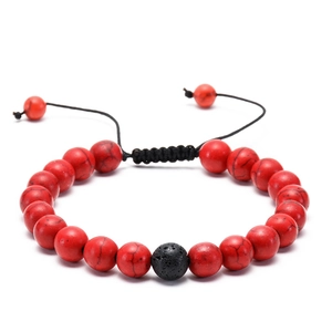 Macro detail of red turquoise-style beads and black lava stone on adjustable woven bracelet