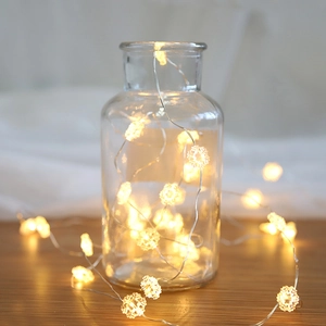 Warm white snowflake LED string lights in a clear glass bottle for Christmas decor