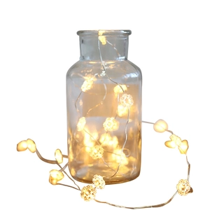 LED snowflake string lights on copper wire inside a glass jar for warm festive decor
