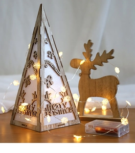 Detail of wooden Merry Christmas pyramid light and reindeer silhouette with LED string lights