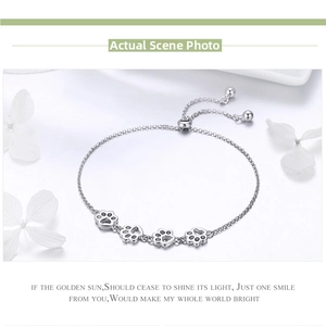 Macro detail of S925 sterling silver bracelet featuring hollow pet paw print charms