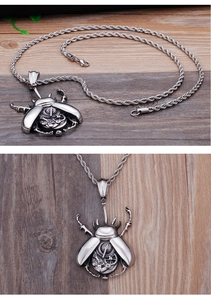 Detail of silver stainless steel beetle pendant with gear mechanics and twisted chain