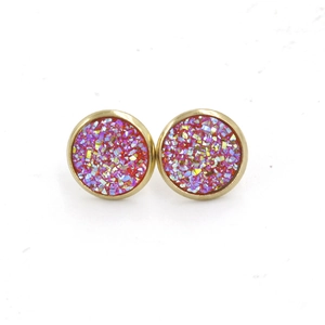 Macro view of 12mm gold-plated stud earrings with pink glitter resin inserts