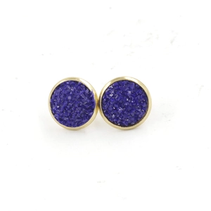Macro detail of 12mm gold-plated stainless steel stud earrings with blue resin stones