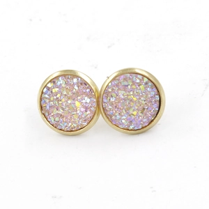 Detailed macro view of 12mm gold-plated stainless steel studs with pink resin crystals