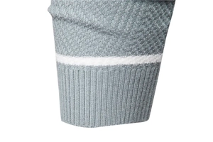 Close-up of grey twill knit sweater featuring ribbed cuffs with a white stripe detail