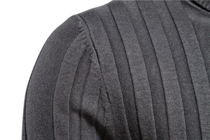 Detail of dark charcoal grey knit sweater showing vertical ribbed texture and shoulder seam