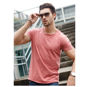 Outdoor model wearing coral pink slub cotton T-shirt with textured detail and round neck