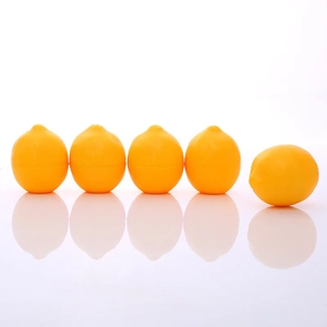 Λεπτομέρεια από πέντε δοχεία lip balm σε σχήμα λεμονιού σε λευκό ανακλαστικό φόντο