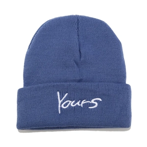 Close-up detail of blue knitted beanie with white Yours cursive script embroidery
