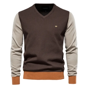 Detail of V-neck knitted sweater featuring color-block design in brown and grey