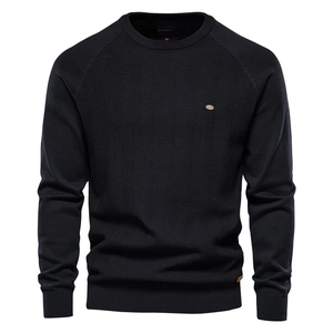 Detailed view of black knitted sweater fabric with brand label and golden logo