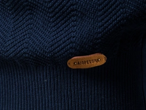 Macro shot of navy blue knit sweater featuring herringbone texture and ribbed hem detail