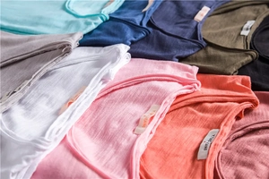 Detailed stack of multi-colored slub cotton V-neck T-shirts showing fabric texture