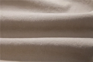 Macro shot of high-quality light khaki cotton twill fabric showing detailed texture and drape