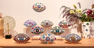 Collection of nine colorful ceramic Evil Eye ornaments displayed on elegant stands
