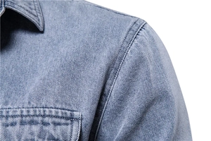 Détail de la veste en jean bleu clair montrant les doubles coutures et la texture du col