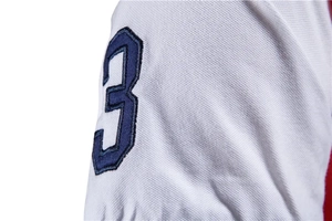 Close-up of number 3 embroidery on white cotton piqué short sleeve Polo shirt cuff