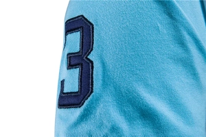 Close-up of navy blue embroidered number three on sky blue piqué cotton polo shirt